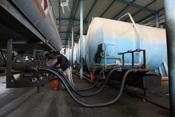 Image: Palestinian worker unloads fuel in Gaza City