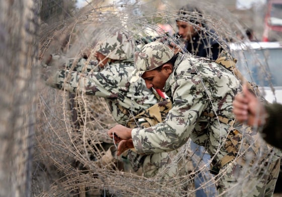 Egyptian soldiers close part of a destroyed section of the border wall between the Gaza Strip and Egypt