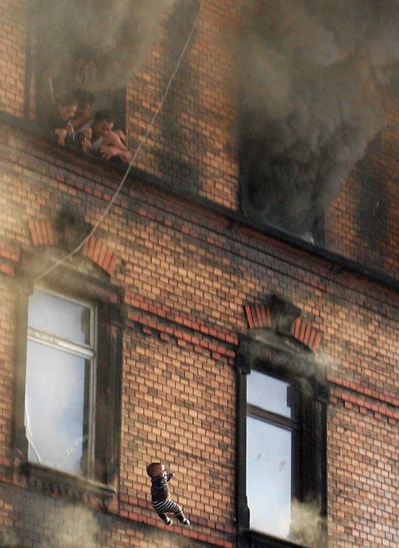 Baby thrown from burning building lives