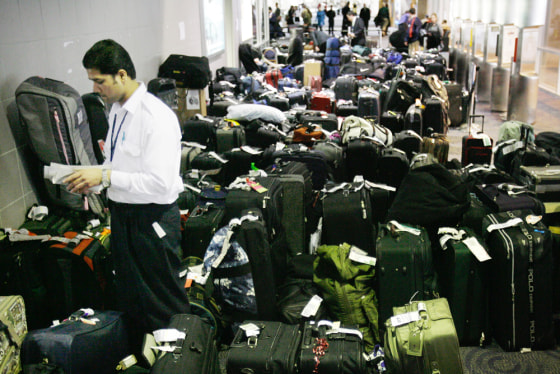 Image: Airport worker surrounded by backlogged luggage