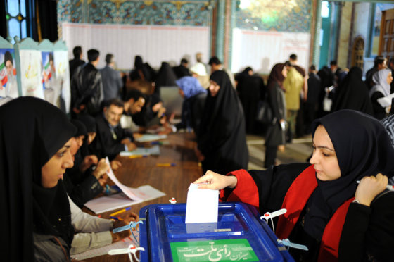 Image: Iranian woman casts her ballot at a polling station in Tehran