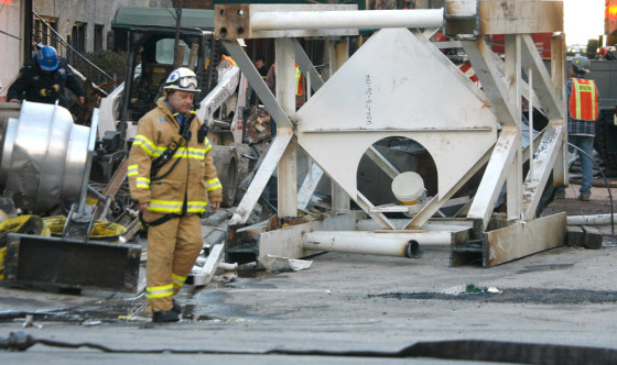 Image: An emergency worker passes a section of crane.