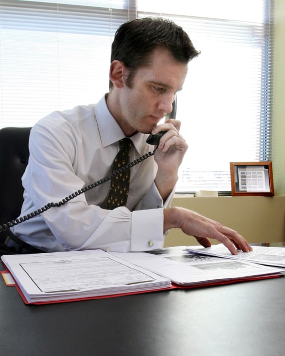 Image: Aloan officer with America East Mortgage, talks with a client about a home loan.