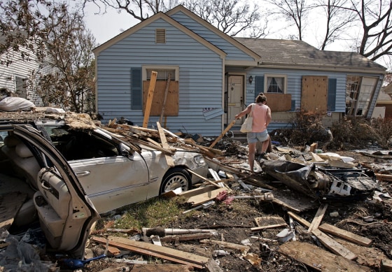 Image: Cheryll Taylor picks her way through debris from Hurricane Katrina strewn all over her front yard