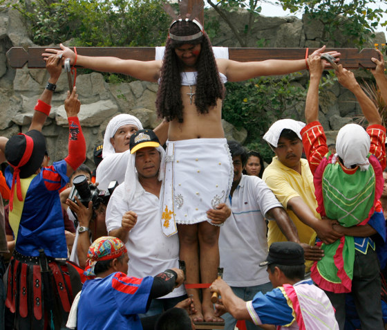 Image: Residents nail a penitent to a wooden cross.