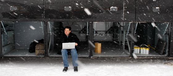 Image: Journalist Mark Halperin works on his laptop in the cargo bay of the campaign press bus