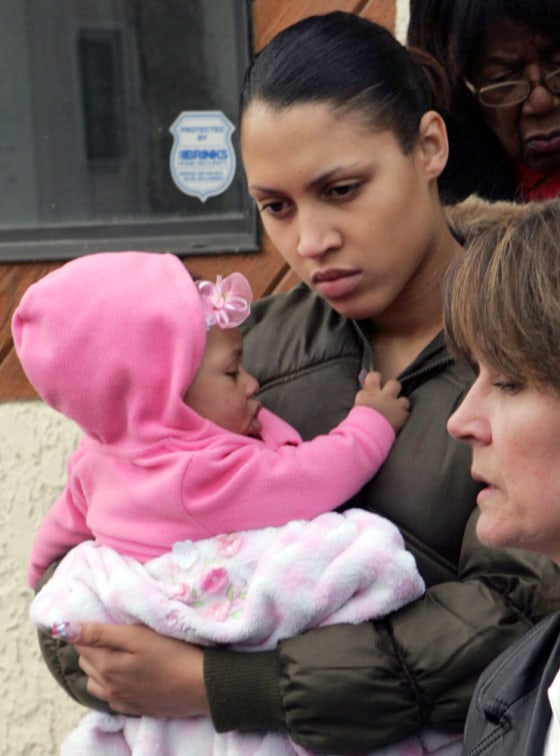 Bree Reuben, the daughter of abducted security contractor Paul Reuben, holds her daughter Ka'Leah Reuben, who was never able to meet her grandfather. Paul Reuben's first wife, Kathy Reuben, is at right.