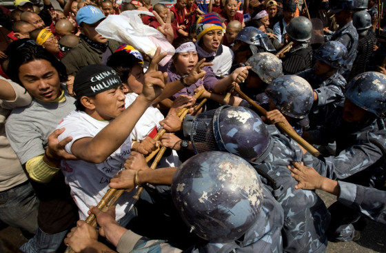 Riot police try to stop Tibetan activists from protesting outside the visa section of the Chinese embassy in Kathmandu