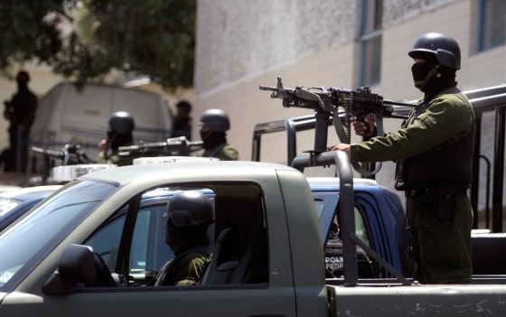 Image: Soldiers stand guard in front of the Tijuana city morgue