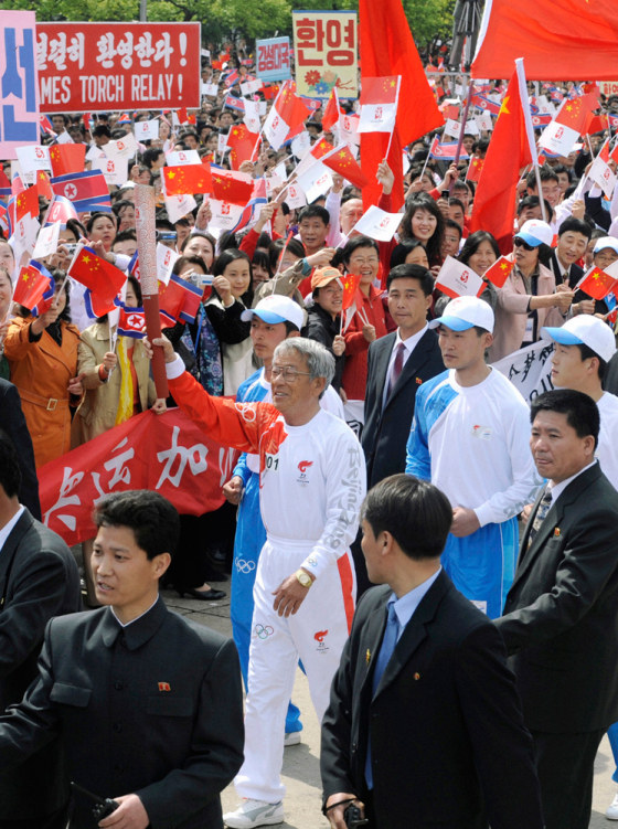 Image: Former North Korean national soccer team player Pak Doo-ik runs with the Olympic torch in Pyongyang