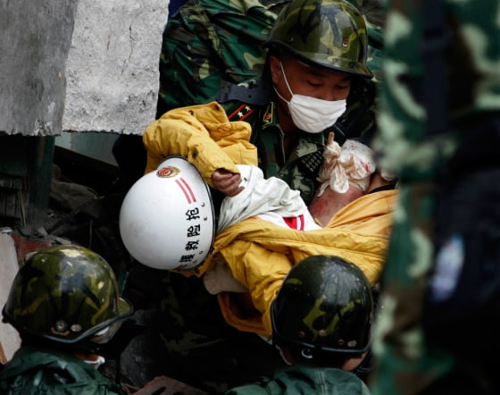 Image: Rescuer carries high-school student Yang Liu from rubble in Hanwang