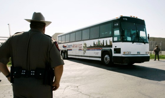 Image: Texas State Troopers, left, and far right, man a roadblock as a bus with members from the Fundamentalist Church of Jesus Christ of Latter Day Saints
