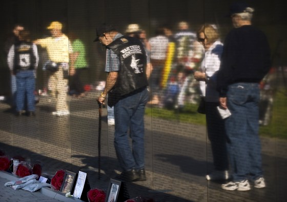Image: Visitors file by the Wall, which currently contains 58,249 names of fallen soldiers