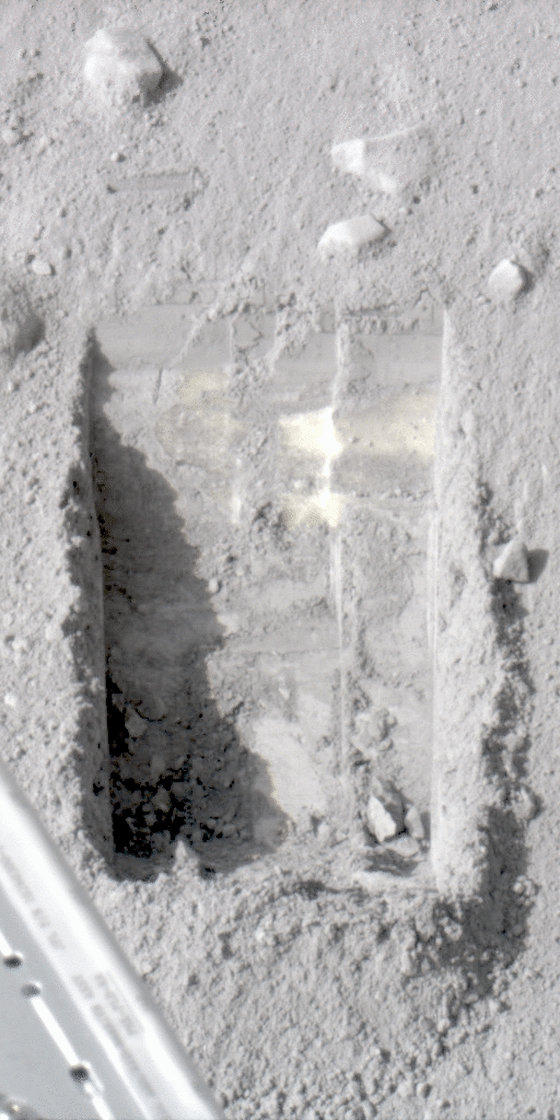 This animated image shows dice-sized bits of ice in the lower left corner of a trench dug by the robotic scoop on NASA's Phoenix Mars Lander. Scientists say they know the bits were ice because they disappeared from view in later imagery.