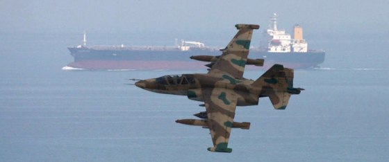 Image: A picture released by Mehr news agency shows an aircraft of Iran's elite Revolutionary Guards flying over an oil tanker during manoeuvres