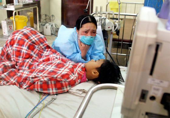 VIETNAMESE WOMAN TENDS TO HER SON WHO IS SUSPECTED OF HAVING BIRD FLU