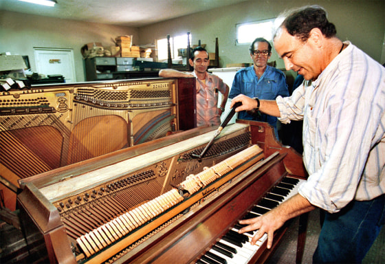 Ben Treuhaft is seen in this 1996 file photo adjusting a piano at Havana's National Music School.
