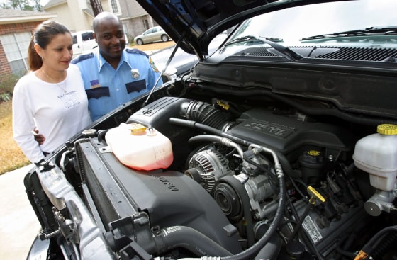 Carlton Jack, right, and his wife Lourdes look at the engine of one of their Hemi-equipped Dodge RAM 1500 pickups at their home in Spring, Texas. Jack was so enamored with the big engine truck that he bought for himself last year, that he bought one for his wife at Christmas.