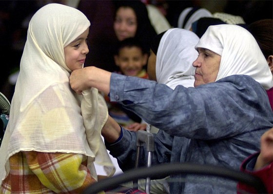 A Muslim woman adjusts the veil of a young girl during a meeting of the Union of Islamic Organizations of France in a May 12, 2002, file photo.
