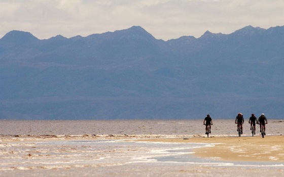 Mark Webber and teamates ride along the beach