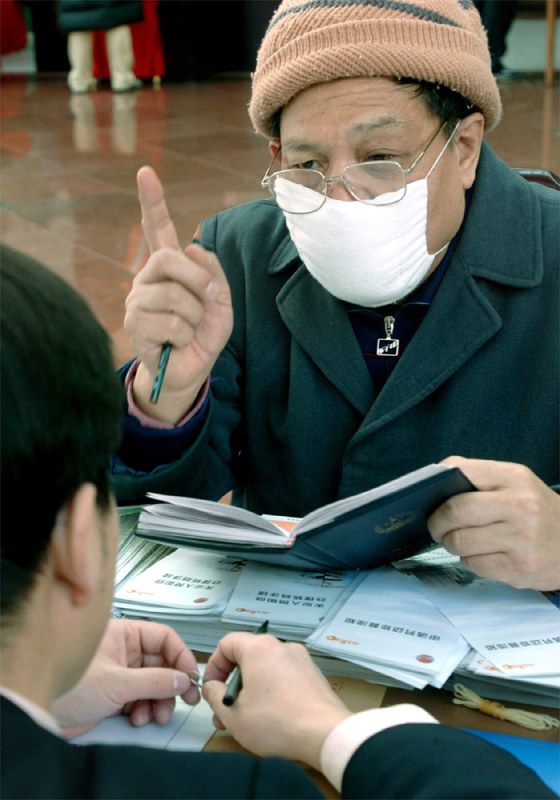 LOCAL REPRESENTATIVE OF THE NPC WEARS A MASK TO WARD OFF SARS IN BEIJING