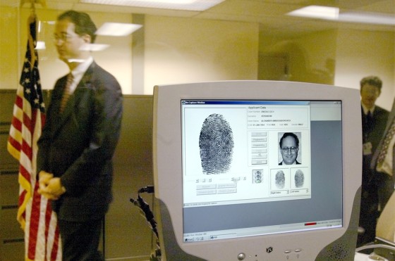 A U.S. embassy official walks past a monitor displaying biometric data during a demonstration of a new procedure, fingerprint scans, to the media at the U.S. Embassy in Moscow late last year. 