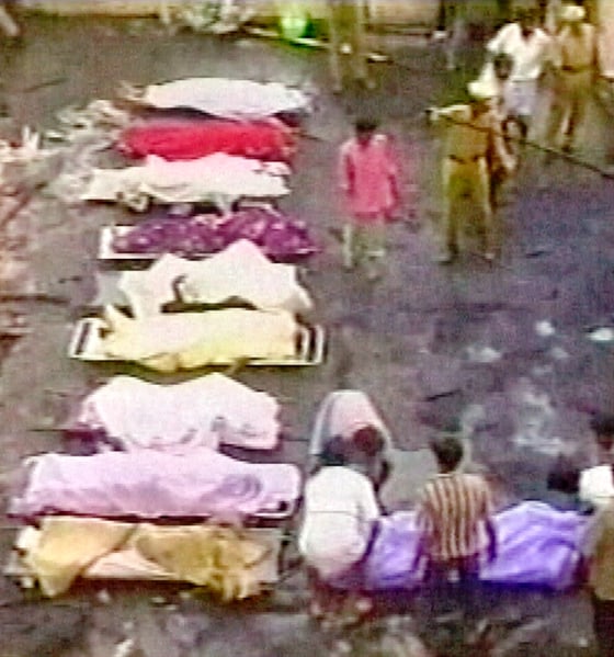 RESCUE WORKERS STAND NEAR VICTIMS OF FIRE AT A WEDDING IN SOUTHERN INDIA
