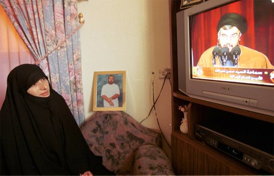 Fadila Qasfi, wife of Lebanese prisoner Jawad Qasfi, who has been held in Israel for 13 years, watches a televised news conference by the leader of Lebanon's militant Hezbollah group Sheik Hassan Nasrallah in her house in the southern Lebanese village of Sultaniyah on Sunday.