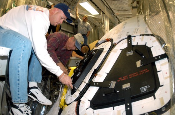 Shuttle maintenance specialists Les Hanks and Mike Young prepare a window on Atlantis for removal and inspection. Atlantis has been undergoing maintenance at Kennedy Space Center in Florida in preparation for the next shuttle mission.