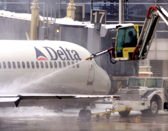 DELTA JET IS SPRAYED WITH CHEMICAL SOLUTION TO REMOVE ICE AT NATIONAL AIRPORT IN WASHINGTON