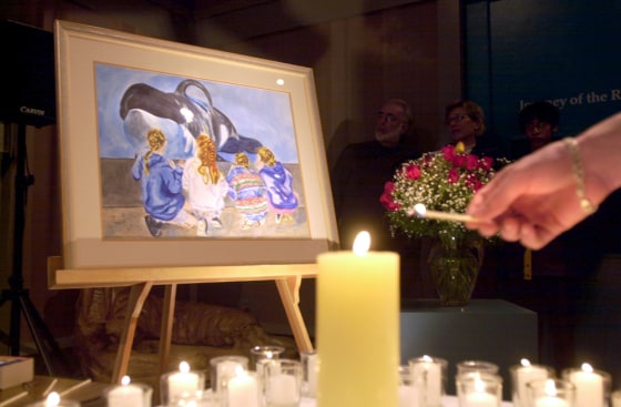 People light candles in memory of the killer whale Keiko during a memorial service at the Oregon Coast Aquarium in Newport, Ore., on Friday.