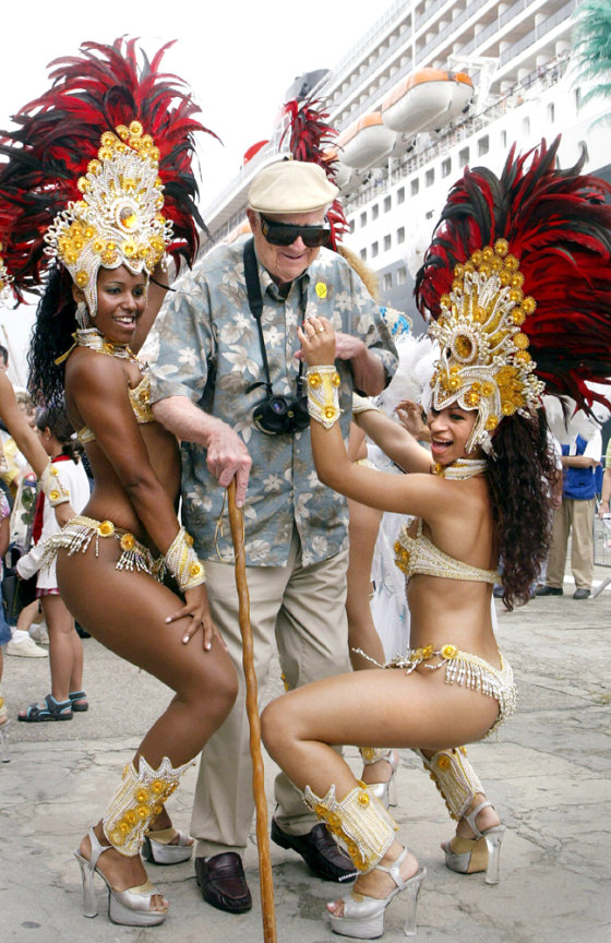 A PASSENGER FROM QUEEN MARY TWO IS WELCOMED BY BRAZILIAN CARNIVAL REVELLERS IN RIO DE JANEIRO
