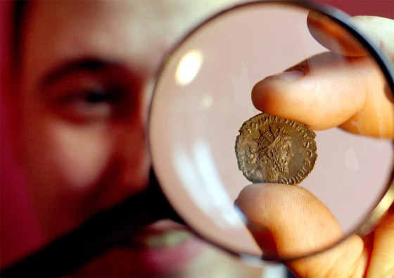 COIN WHICH DISPLAYS HEAD OF VIRTUALLY UNKNOWN ROMAN RULER DOMITIANUS IS SHOWN