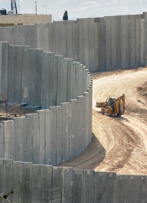 BACKHOE DRIVES NEAR CONCRETE SECURITY WALL IN EAST JERUSALEM