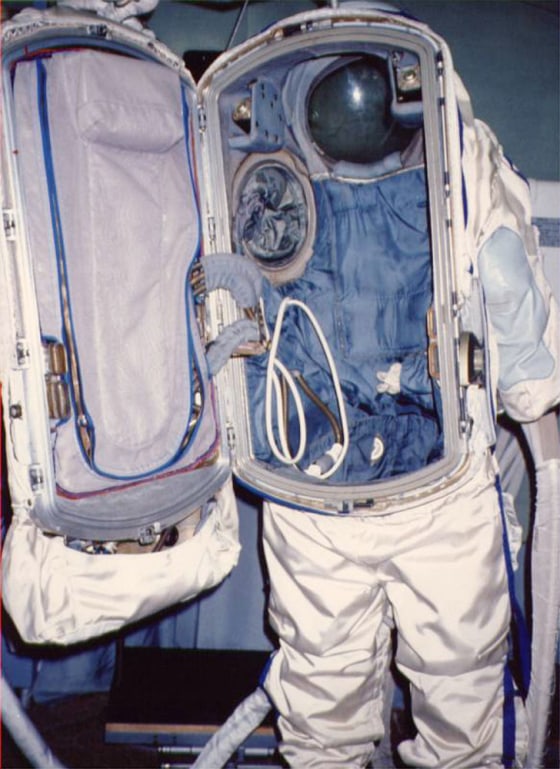 This Russian Orlan spacesuit opens in the back to reveal tubes and equipment. A spacewalker enters the suit through the back hatch.