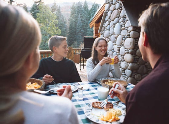 Image: A family gathers for breakfast outside at a lodge