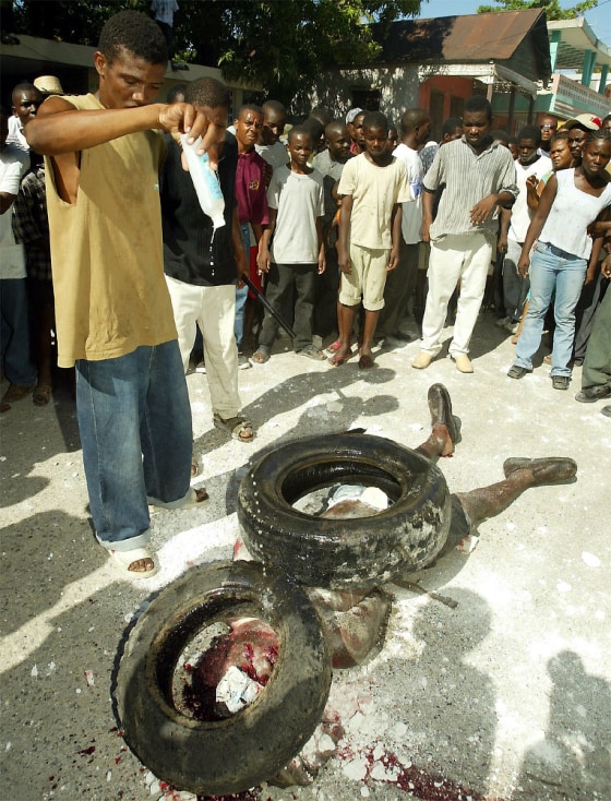 MAN POURS GASOLINE ON SUSPECTED HAITIAN ASSASSIN