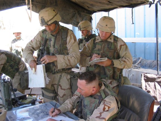 At a makeshift command post in a Pepsi bottling plant in southern Baghdad, Maj. Gen. David H. Petraeus (seated) confers last April with his 3rd Brigade commander, Col. Michael S. Linnington, left, and the assistant division commander for operations, Brig. Gen. Benjamin C. Freakley.