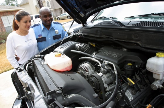 Carlton Jack, right, and his wife Lourdes look at the engine of one of their Hemi-equipped Dodge RAM 1500 pickups at their home in Spring, Texas last month. Jack was so enamored with his big-engine truck that bought one for his wife at Christmas.