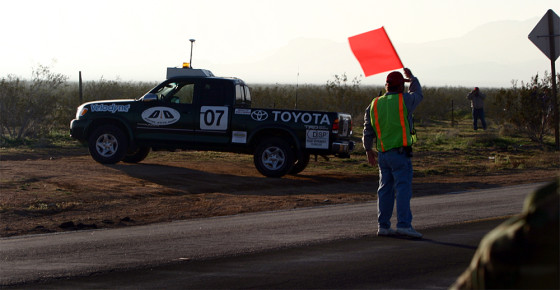 A driverless Toyota Tundra pickup, fielded by Digital Auto Drive, accelerates into the desert Saturday after crossing a highway near the starting line for the DARPA Grand Challenge.