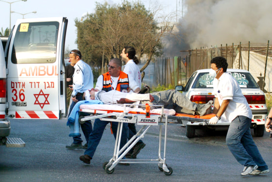 Rescue workers carry a wounded victim from the scene of a double suicide bombing in the southern Israeli port city of Ashdod on Sunday.