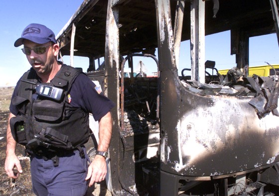 UN POLICE INSPECT BURNT OUT BUS IN KOSOVO
