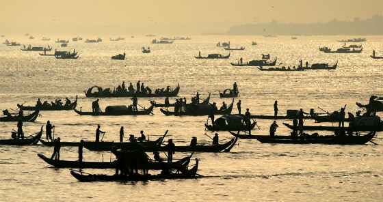 CAMBODIAN FISHERMEN SET OUT AT DAWN ON THE MEKONG RIVER