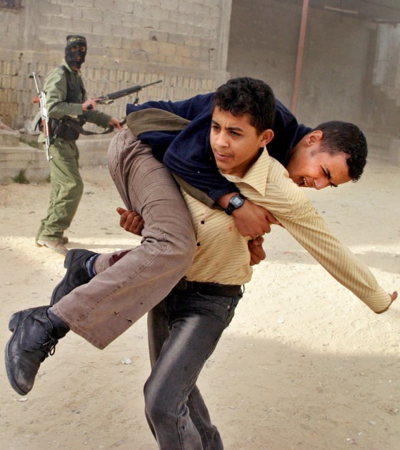 A wounded Palestinian youth is rushed from the scene following an Israeli helicopter missile strike in the Rafah refugee camp, southern Gaza Strip, Thursday.