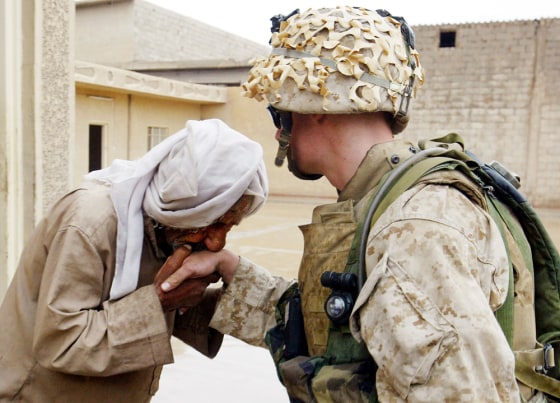 An Iraqi civilian kisses the hand of U.S. Marine Cpl. Joseph Sharp after Marines from the 1st Battalion 5th Marines gave him a supply of food and water in Fallujah, Iraq, Monday.