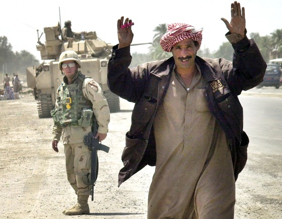 An Iraqi man passes through a checkpoint at the entrance to the embattled Baghdad suburb of Abu Ghraib, Iraq, on Saturday.