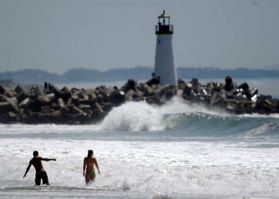 People cool off in the surf at Seabright State Beach on a sunny, warm afternoon in Santa Cruz, Calif., on Monday.
