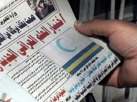 An Iraqi newspaper showed the nation's new flag on its cover Monday. The crescent represents Islam.