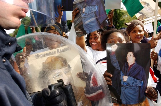 Supporters of Moammar Gadhafi show photos and posters of the Libyan leader outside European Union Commission headquarters in Brussels Tuesday.