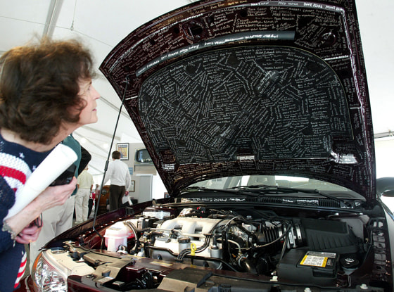 Beverly Bolton looks for the signature of her son-in-law on the hood of the last ever Oldsmobile, an Alero, which rolled off the production line early Thursday.